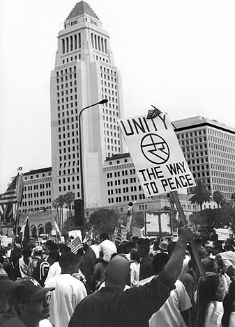 A man is seen holding a unity symbol sign during a demonstration for immigrant rights in Downtown Los Angeles on March 25th, 2006