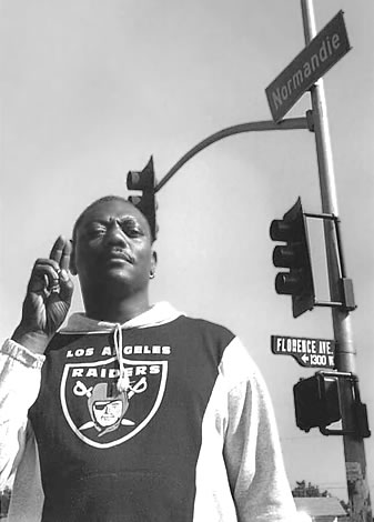 Unity Corps supporter flashes a unity hand sign at the corner of Florence and Normandie (flashpoint of the 1992 L.A. Riots) in South Central, Los Angeles